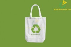 white cloth bag with Recycle sign logo and words "No more Plastic"  on green blackground.eco friendly concept